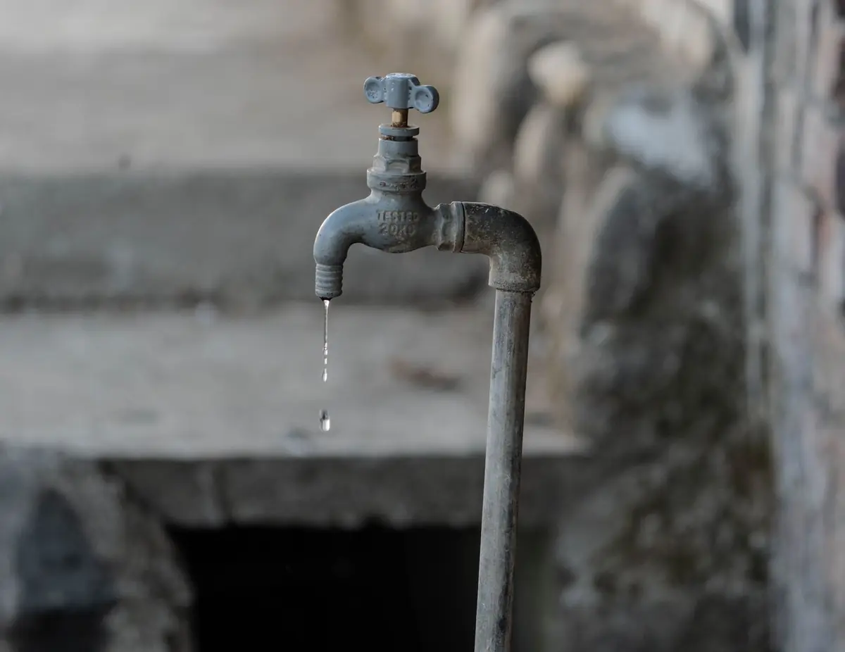 An outdoor faucet dripping water, part of freeze protection for Sherman, TX homes