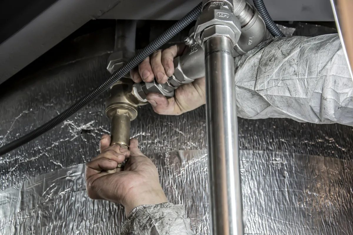 Hands fitting steel pipework during an emergency repair in Sherman, TX